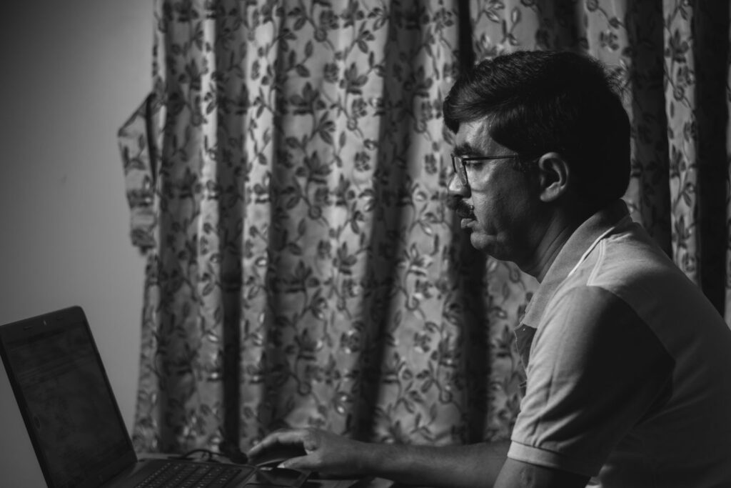 Man met bril werkt geconcentreerd op een laptop