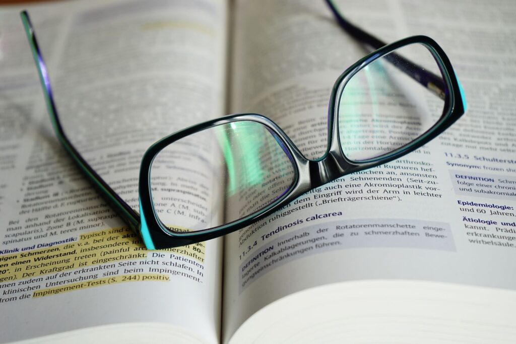 Leesbril op een opengeslagen boek met gemarkeerde regels