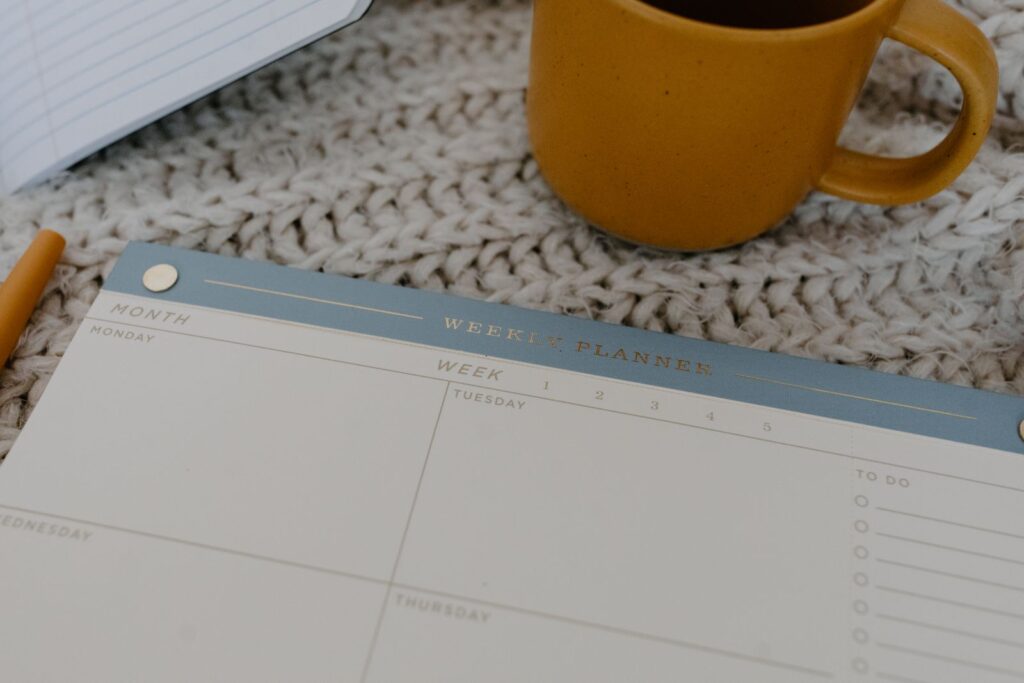 Weekplanner naast een gele koffiemok